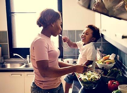 Young mother cooks with toddler